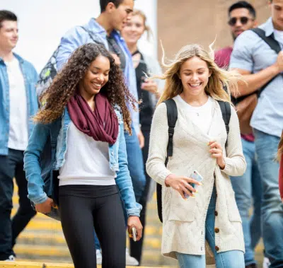 two college aged women walking on campus