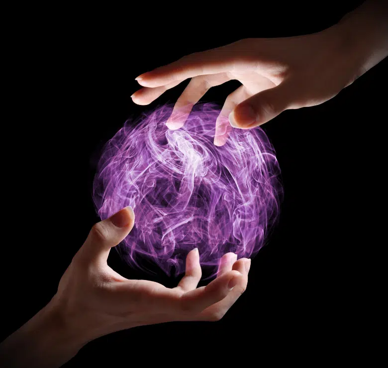 women's hands delicately holding a futuritic purple and white sphere