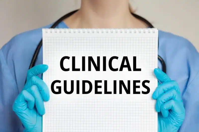 healthcare professional holding a sign that says clinical guidelines