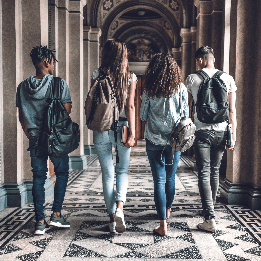 Young students walking down a college campus hallway